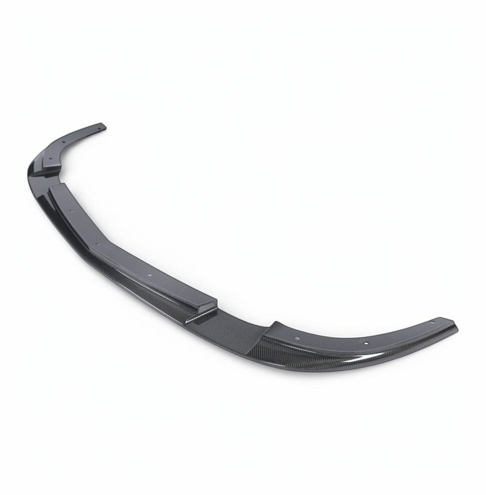 A curved carbon fiber automotive body part, likely a lip spoiler or rear diffuser, shown on a clean white background.