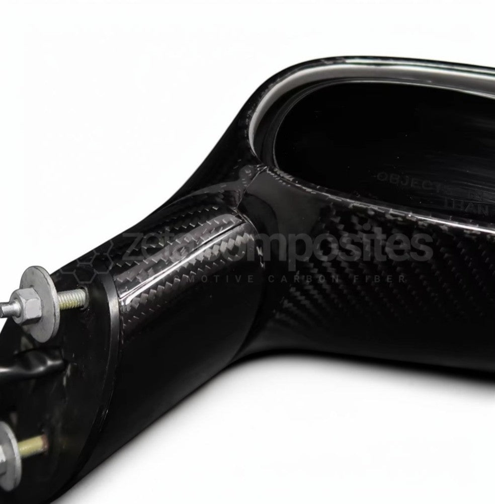 A close-up of a glossy black carbon fiber automotive part, showing the woven carbon fiber pattern and a silver metal bolt fastener, on a white background.