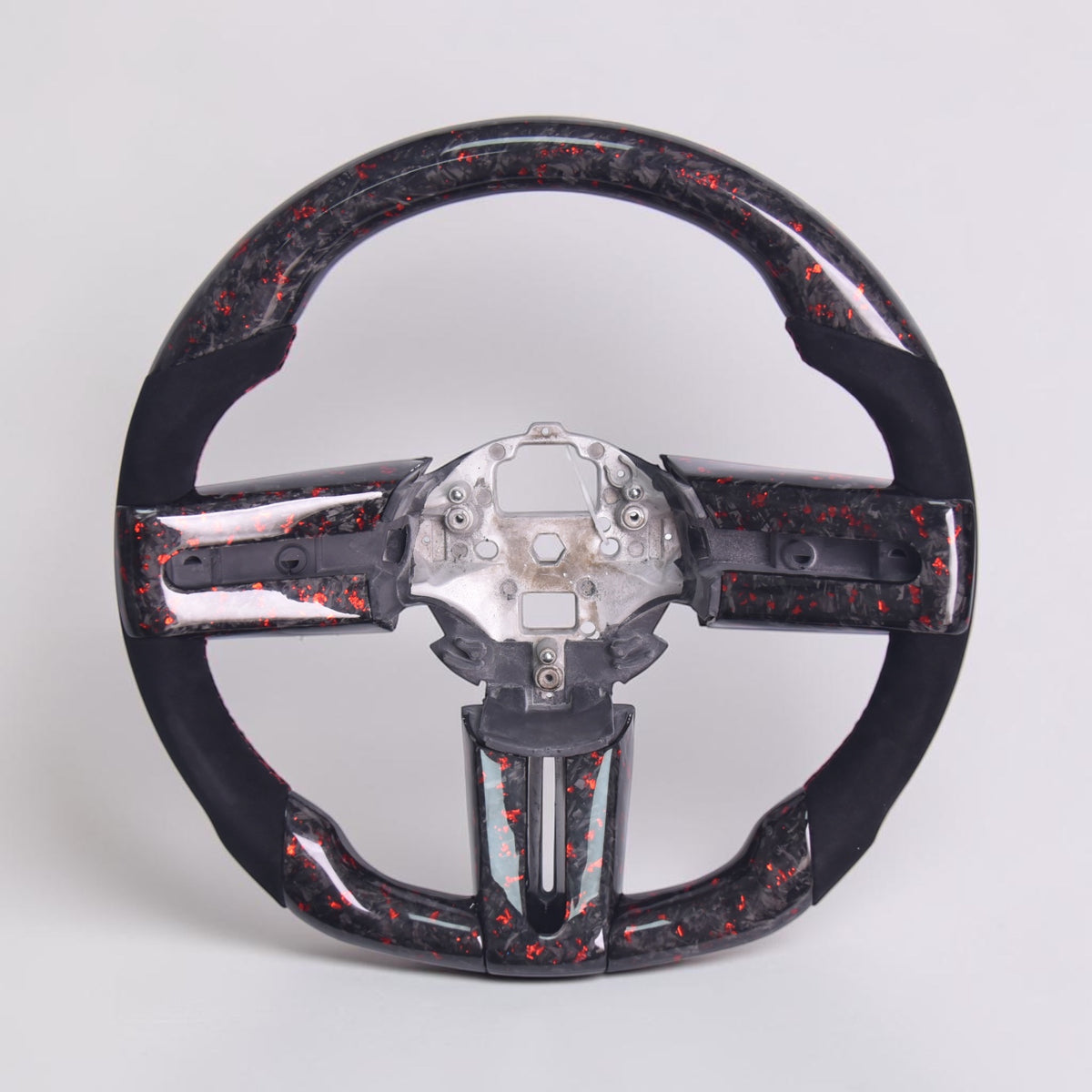 Carbon fiber steering wheel with black and red marbled trim and exposed central mounting hub
