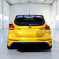 A bright yellow Ford Focus RS hatchback shown from the rear, parked inside a clean, white industrial showroom.