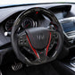 Carbon fiber steering wheel in a car interior, black leather with red stitching and controls