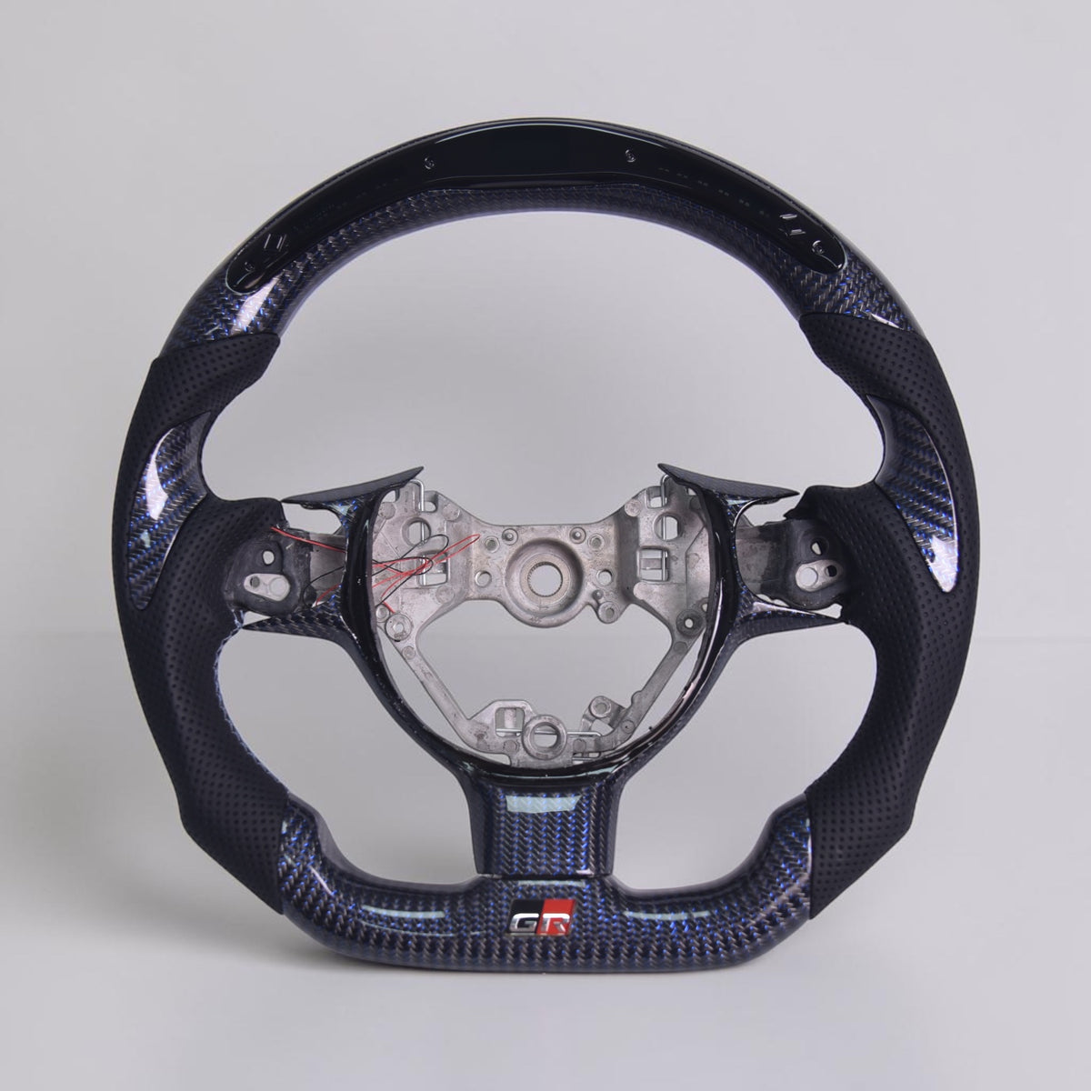 Custom carbon fiber steering wheel with blue accents and exposed center mounting hub