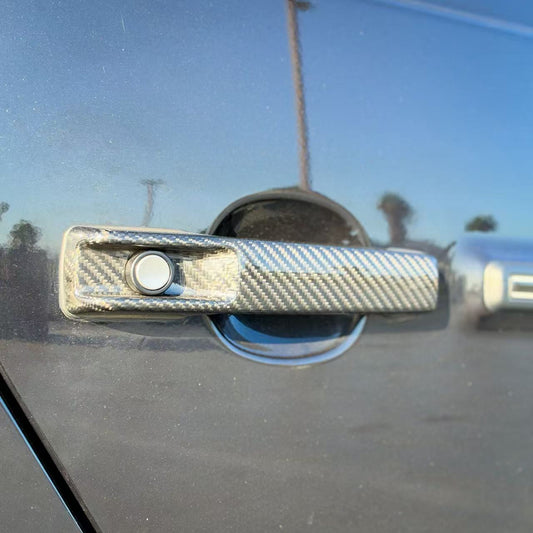 Carbon fiber door handle cover with circular cutout and silver-gray weave