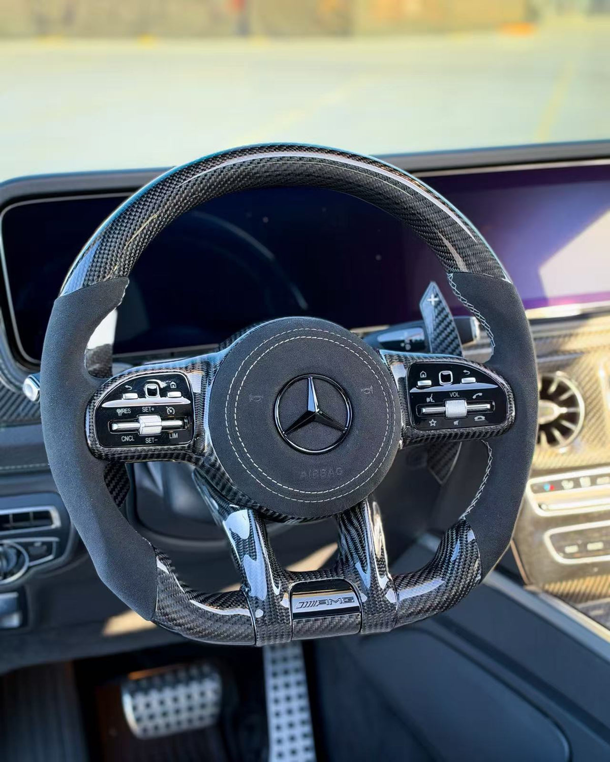 Carbon-fiber steering wheel upgrade with black leather grip and Mercedes logo center