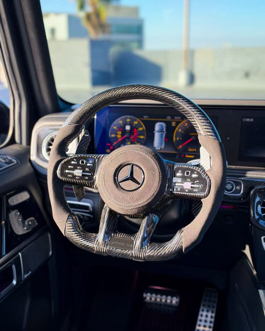 Carbon-fiber steering wheel upgrade with tan center pad and Mercedes logo
