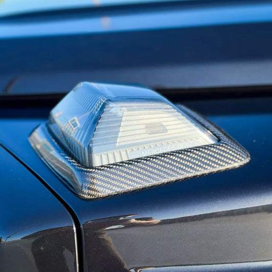 Turn signal lens with carbon fiber cover, showing textured trim detail