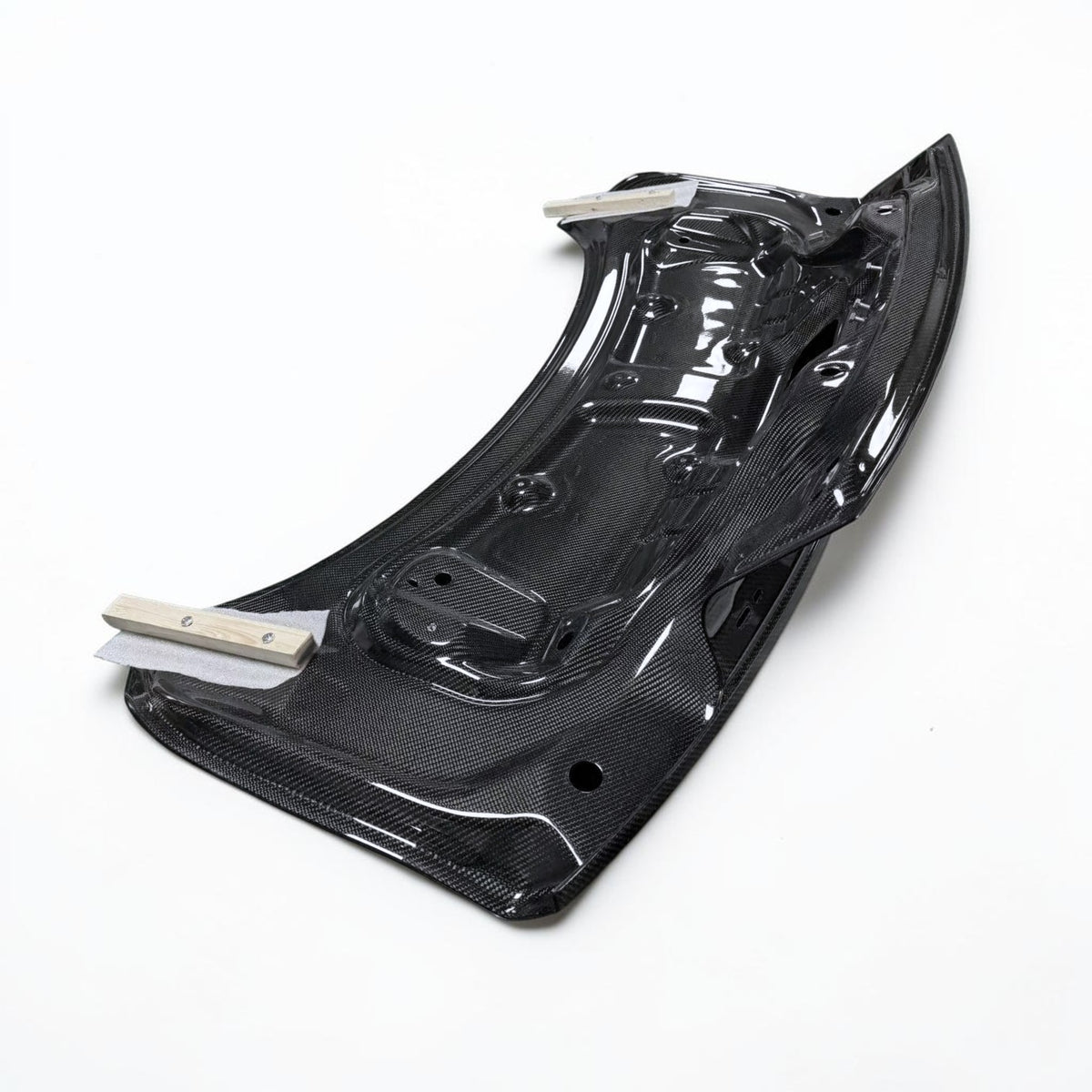 Underside of carbon fiber trunk panel, black weave with mounting holes
